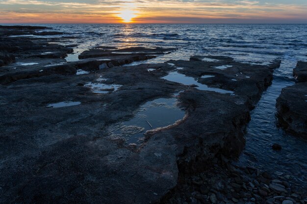 クロアチア、イストリア半島のサヴドリアにあるアドリア海の奇岩と海岸に沈む夕日