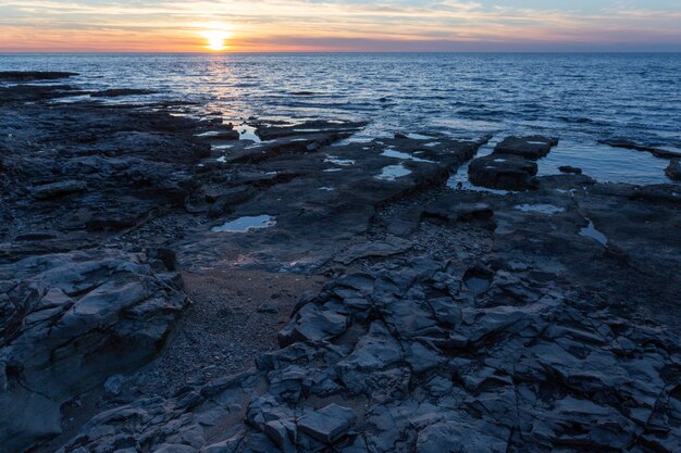 クロアチア、イストリア半島のサヴドリアにあるアドリア海の奇岩と海岸に沈む夕日