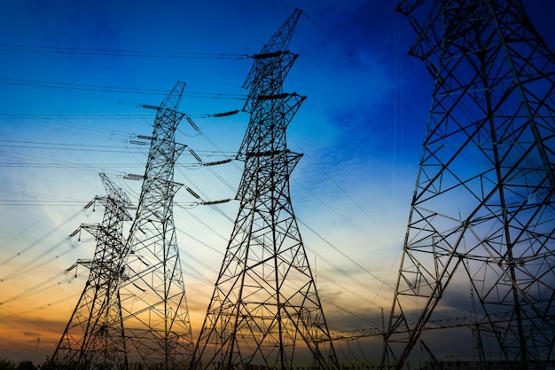 Sun setting behind the silhouette of electricity pylons