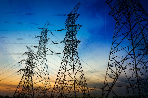 Sun setting behind the silhouette of electricity pylons