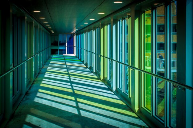 다채로운 창문으로 디자인된 현대적인 건물의 복도에서 빛나는 태양