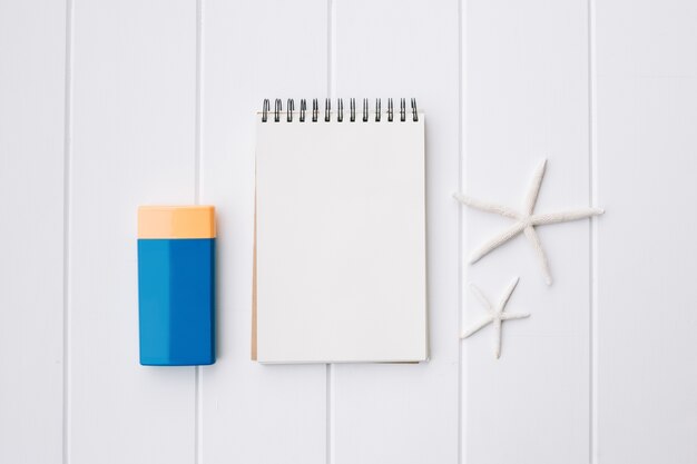 suncream bottle and notebook and starfish for beach