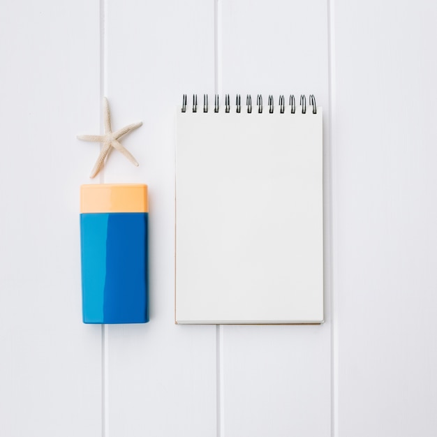 suncream bottle and notebook and starfish for beach