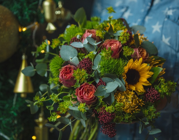 Букет солнцецвета и розы в предпосылке рождества изображение