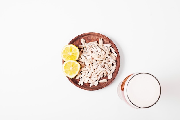 Sunflower seeds and beer on white.