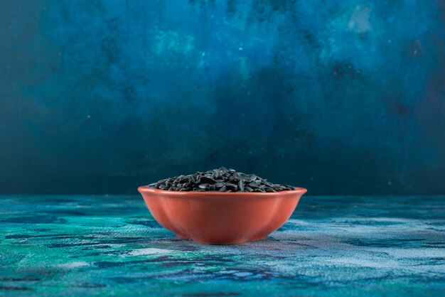 Sunflower seeds in a bowl on the marble surface