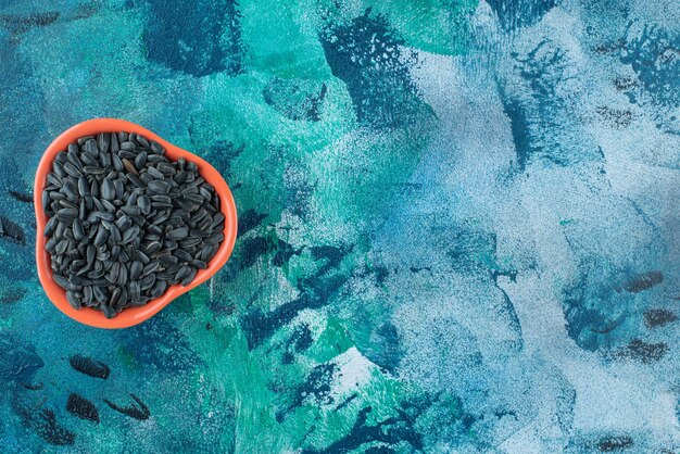 Sunflower seeds in a bowl, on the marble table.