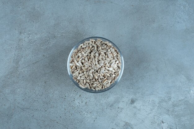 Sunflower seeds in a glass cup on blue background. High quality photo