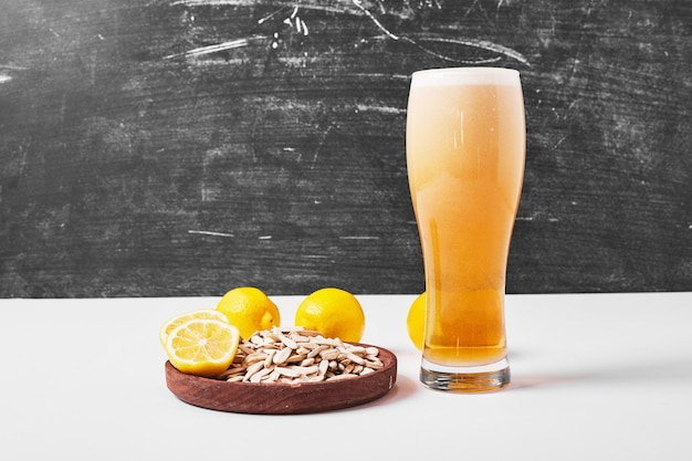 Sunflower seeds with lemon and beer on white.