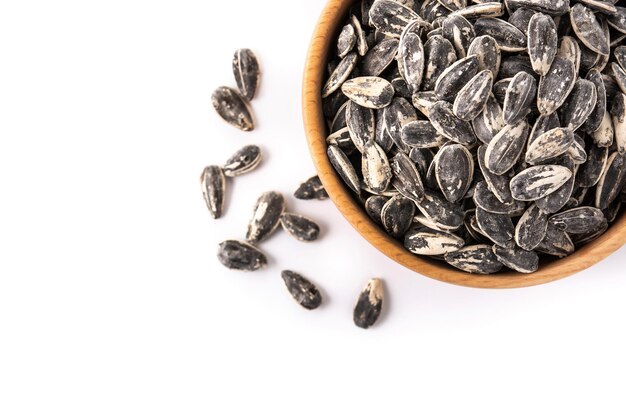 Sunflower seeds in wooden bowl isolated on white background Copy space