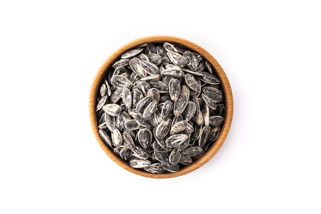 Sunflower seeds in wooden bowl isolated on white background