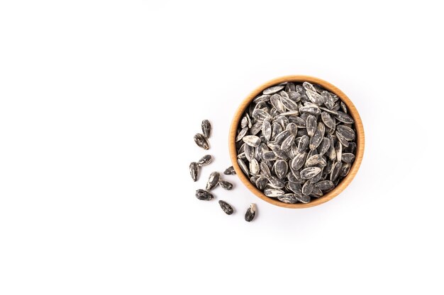 Sunflower seeds in wooden bowl isolated on white background