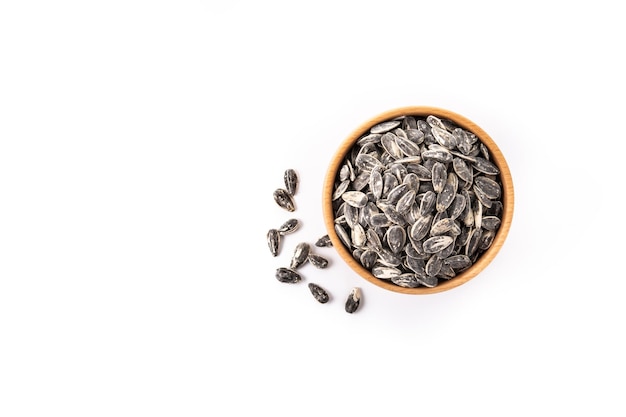 Sunflower seeds in wooden bowl isolated on white background