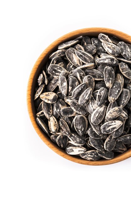 Sunflower seeds in wooden bowl isolated on white background