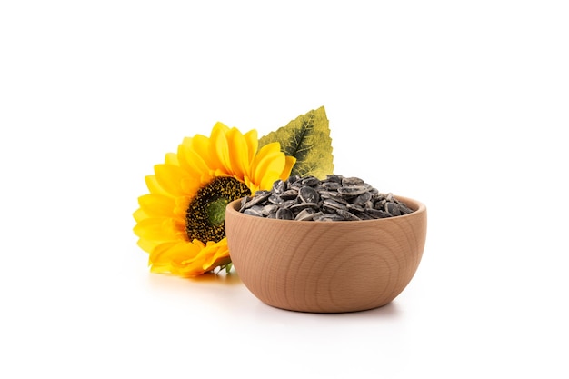 Sunflower seeds in wooden bowl isolated on white background