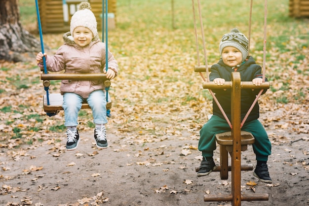 Sunlit children swinging on autumn playground
