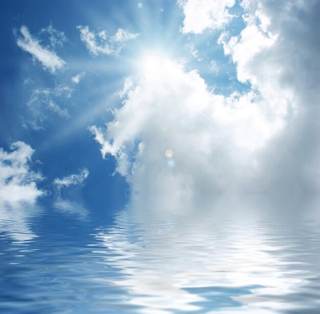 Солнечное голубое небо отражается в воде