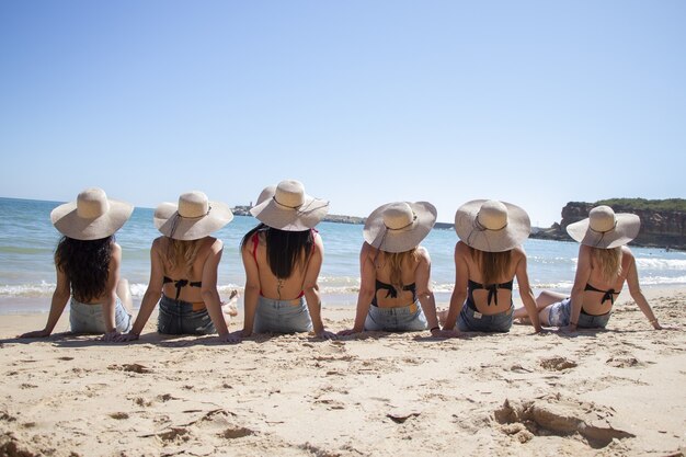 Солнечный пейзаж молодых женщин в бикини, позирующих на пляже