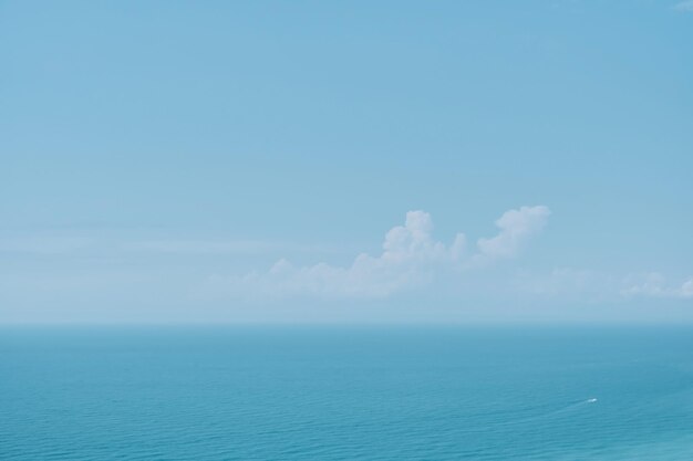 晴れた空と雲と正午の背景に穏やかな海 ソフトぼやけたフォーカス 暑い夏休みのパステル カラーと太陽のまぶしさ 抽象的なぼかしポスターまたは広告バナー