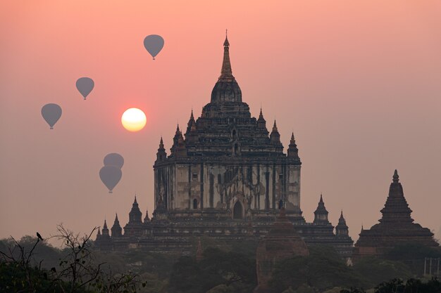 Sunrise in bagan, myanmar, with hot air balloons starting their flight