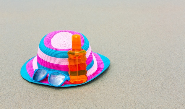 SUMMのためのビーチでの帽子と日焼け止めローションとサングラス