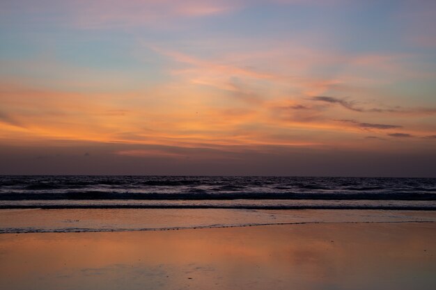 Sunset with the waves breaking on the beach