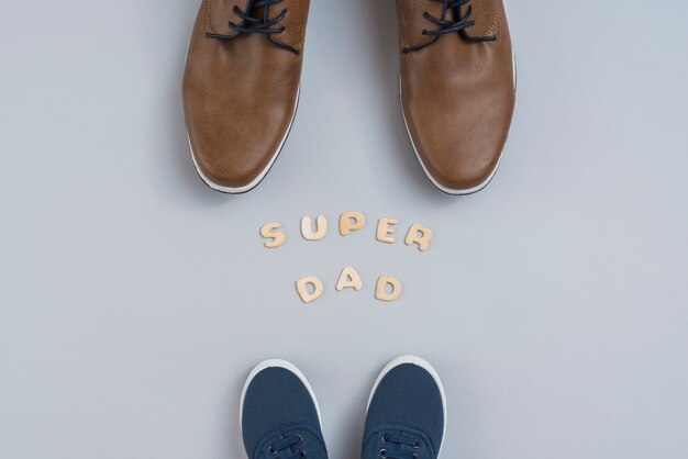 Super dad inscription with man and children shoes 