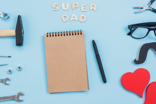 Super dad inscription with notepad and tools 