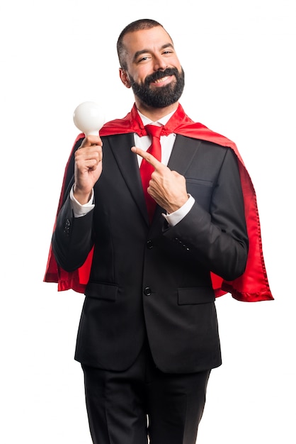 Super hero businessman holding a bulb