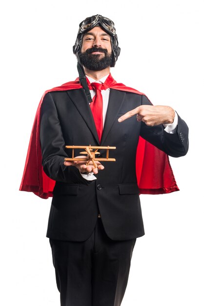 Super hero businessman holding a wooden toy airplane
