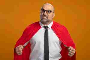 Бесплатное фото Бизнесмен супергероя в красной накидке и очках, сжимая кулаки, сердитый и разочарованный