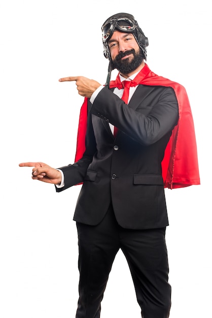 Super hero businessman pointing to the lateral