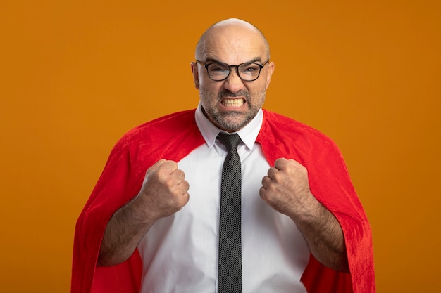 Free photo super hero businessman in red cape and glasses clenching fists crazy mad