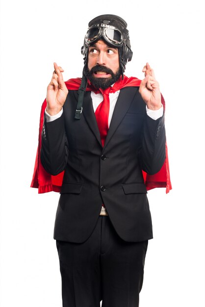 Super hero businessman with his fingers crossing