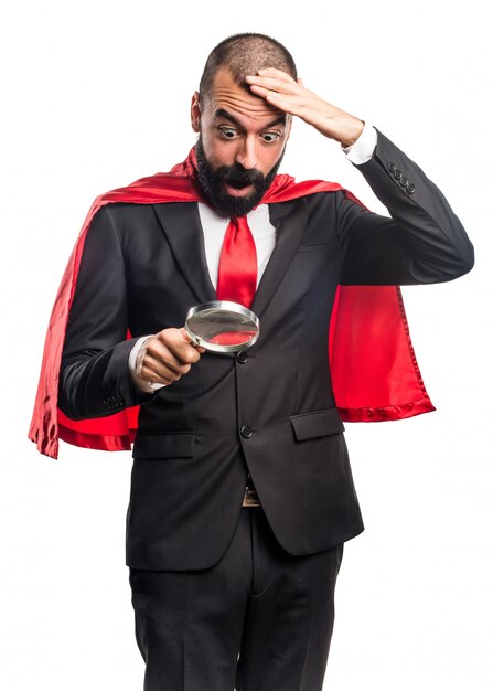 Super hero businessman with magnifying glass