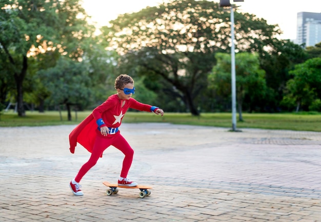 Foto gratuita ragazzo supereroe su uno skateboard