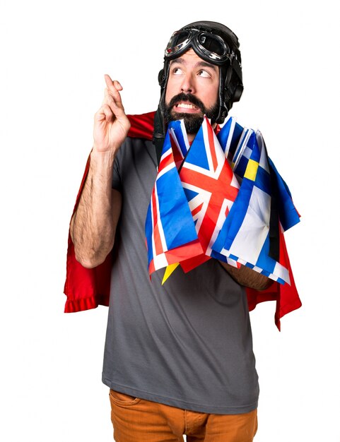 Superhero with a lot of flags with his fingers crossing