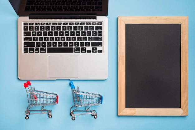 Supermarket carts near laptop and photo frame