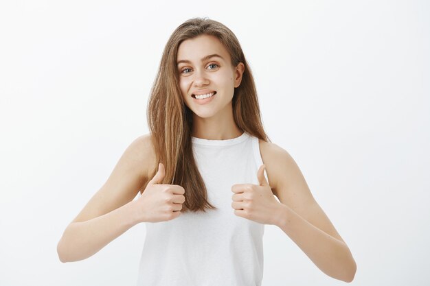 Supportive attractive woman showing thumbs-up, praise good choice, making compliment, saying yes, approve