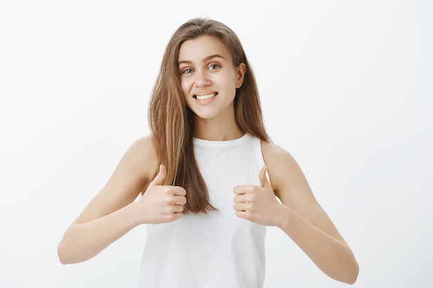 Supportive attractive woman showing thumbs-up, praise good choice, making compliment, saying yes, approve