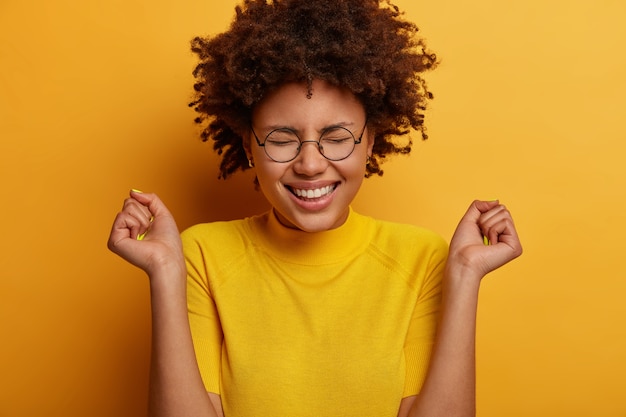 Supportive dark skinned woman with Afro hairstyle, being real fan