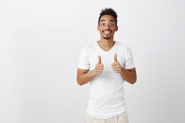 Supportive handsome african american man showing thumbs-up in approval, like idea, praise good choice