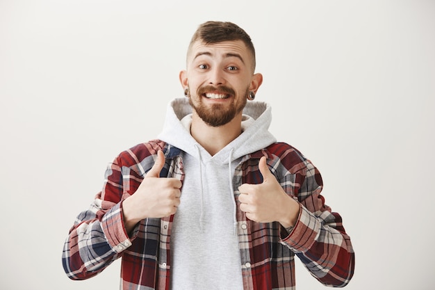 Free photo supportive happy smiling man showing thumbs-up, praising good job, well done