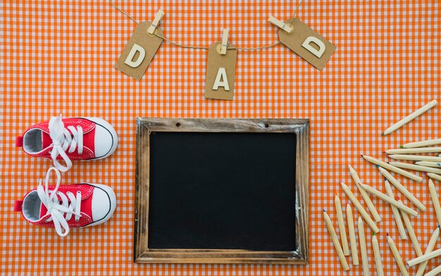 Surface with slate, pencils and shoes for father's day