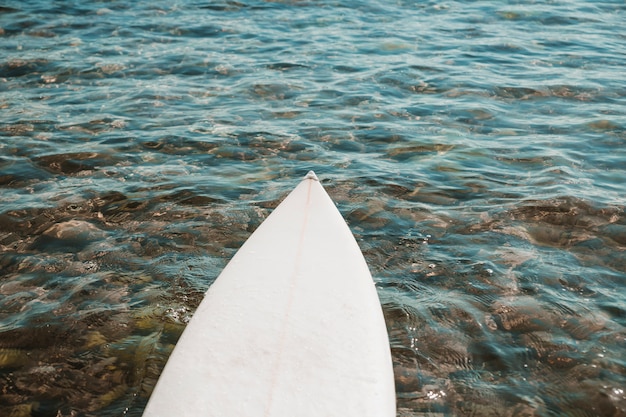 Surfboard lying on clean water