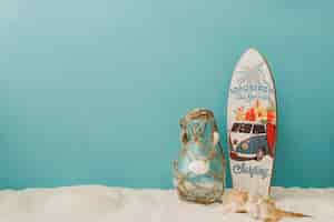 Free photo surfboard, mollusks and bottle on blue background