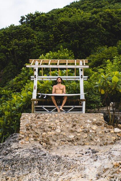 Surfboard Surfer Outdoor Sport Tropical Ocean Concept. Young handsome man with a surfboard on the ocean.