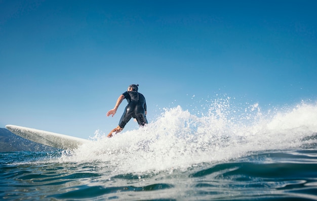 Surfer riding wave alla luce del giorno