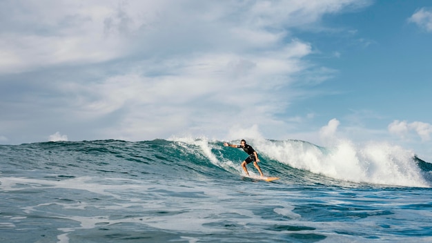 Surfer riding wave in daylight