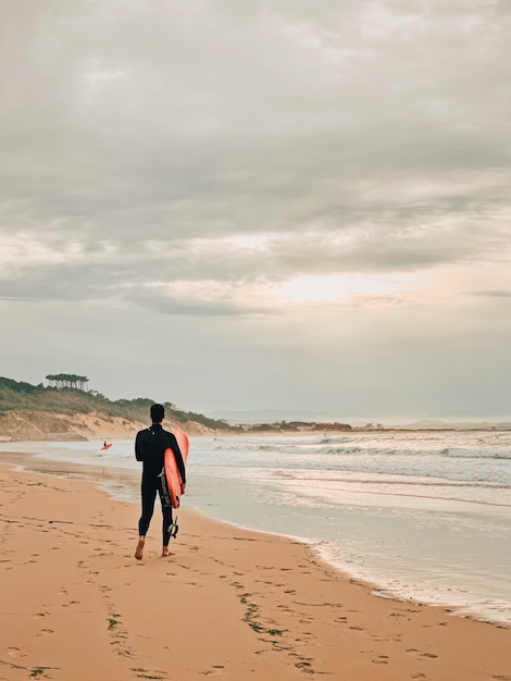 Foto gratuita surfer in spiaggia sabbiosa
